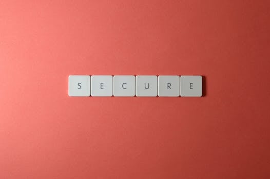 A close-up of the word 'Secure' spelled out with tiles on a red surface, ideal for security concepts.