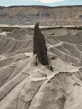 A towering rock formation in the arid desert landscape of Hanksville, Utah.