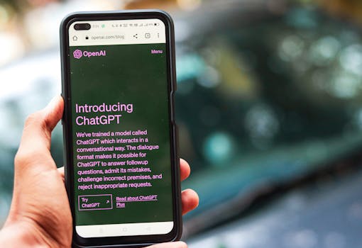 Close-up of a smartphone showing ChatGPT details on the OpenAI website, held by a person.