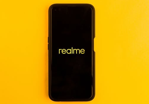 Realme smartphone displayed against a bright yellow backdrop, emphasizing modern technology.