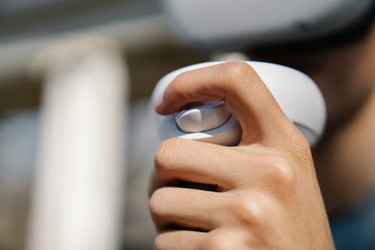 Close-up of a hand holding a VR controller outdoors, showcasing modern technology.