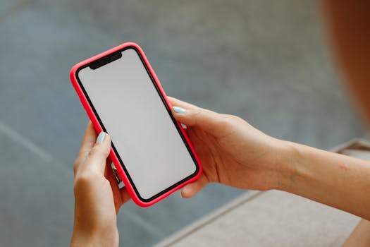 Close-up of hands holding a smartphone with blank screen, great for mockups.